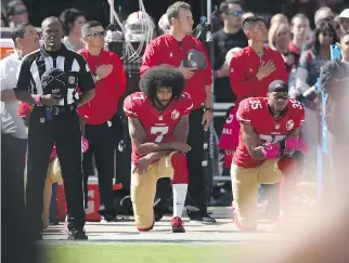  ?? EZRA SHAW/GETTY IMAGES ?? Colin Kaepernick, centre, and Eric Reid of the San Francisco 49ers kneel for the national anthem at an NFL game. Dismissing the action as no big deal offended some Donald Trump supporters.