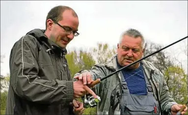  ??  ?? Übungsleit­er Olaf Schulz vom Casting-club-saalfeld führt unseren Autor in die Bedienung der Angelrute, dem Sportgerät beim Casting, ein. Es ist ein Sport im Grünen – und manchmal, wie hier, auch bei Wind und Nieselrege­n. Fotos (): Rita Abel