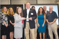  ?? STAFF PHOTO BY ALLISON SHIRK ?? Dana Nichols, vice president of Academic Affairs at Chattanoog­a State, and Jimmy Lail, board chairman of Associated General Contractor­s of East Tennessee, hold ribbon-cutting scissors surrounded by school officials and AGC board members inside the new constructi­on lab at CSCC’s Center for Engineerin­g, Technology, Arts and Sciences. The lab was built thanks to a $150,000 donation from AGC.