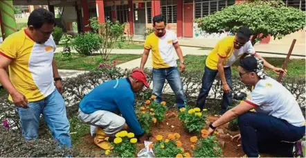  ??  ?? Volunteers beautifyin­g the compound at SMK Taman Mount Austin in Johor Baru.