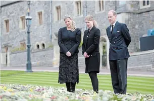  ?? STEVE PARSONS THE ASSOCIATED PRESS ?? Prince Edward, Lady Louise Windsor and Sophie Countess of Wessex view flowers outside St George's Chapel, at Windsor Castle ahead of the Saturday funeral service for Prince Philip.