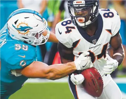  ?? Joe Amon, The Denver Post ?? Broncos wide receiver Isaiah McKenzie is stripped of the ball by the Dolphins’ Chase Allen while returning a punt last season in Miami. McKenzie fumbled the ball six times in 2017, losing two of those.