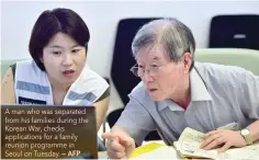  ?? — AFP ?? A man who was separated from his families during the Korean War, checks applicatio­ns for a family reunion programme in Seoul on Tuesday.