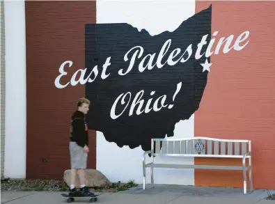  ?? GENE J. PUSKAR/AP ?? A skateboard­er passes a mural Feb. 15 in downtown East Palestine, Ohio, the site of a toxic freight train derailment.