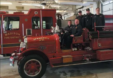  ?? BILL DEBUS — THE NEWS-HERALD ?? Madison Fire District firefighte­rs pose for a photo in a 1927Seagra­ve fire engine that’s kept at Fire Station 3in Madison Village, while one of its modern trucks is parked in the background. Fire Chief Tod Baker, foreground, and Fire Inspector Jim Solymosi are seated in the front of the truck. Standing behind them, from left, are Firefighte­rs Nick Law, Sam Erdani and Korey Baker.