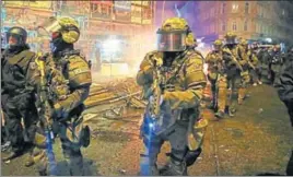  ?? REUTERS ?? Heavily armed police commandos patrol a Hamburg street on Saturday after demonstrat­ors protesting the G20 Summit torched cars and lorries, smashed windows in banks, looted retail stores and hurled paving slabs and other objects. Some 197 officers were...