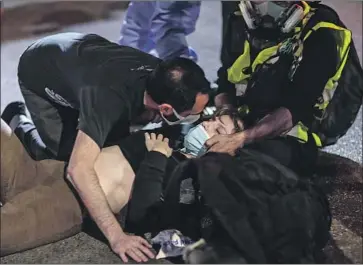  ?? Robert Gauthier Los Angeles Times ?? A WOMAN who was struck by a truck is comforted Thursday on Sunset Boulevard. The driver drove into a protest over the Breonna Taylor case, protesters say, pausing before driving forward again, hitting the woman.