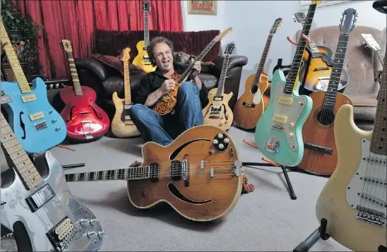  ??  ?? Musician Russell Marsland with a few guitars from his collection. Marsland owns more than 40 guitars, which he keeps in a warehouse. His first guitar was an American-made Kay Electric, two pickup, tobacco sunburst. Les Bazso/PNG