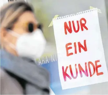  ?? FOTO: PETER KNEFFEL ?? Einkaufen mit Maske macht nur bedingt Spaß. In Trossingen verzeichne­n die Geschäfte weniger Kundschaft nach Einführung der Maskenpfli­cht.