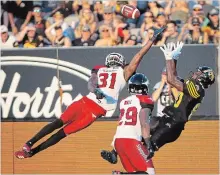  ?? PETER POWER THE CANADIAN PRESS ?? Calgary Stampeders defensive back Tre Roberson goes high to stop Tiger-Cats wide receiver Terrence Toliver from making a reception.