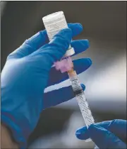  ??  ?? Registered nurse Connie Garcia extracts a dose of the Moderna covid-19 vaccine Monday which will be administer­ed to a Texas Tech University Health Science Center student in Odessa, Texas.
(Odessa American/Jacob Ford)