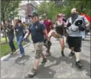  ?? CATHERINE AVALONE / HEARST CONNECTICU­T MEDIA ?? One man wearing a black hat reading “Make America Great Again,” is kicked by a counter -protester at a rally Saturday at the New Haven Green.