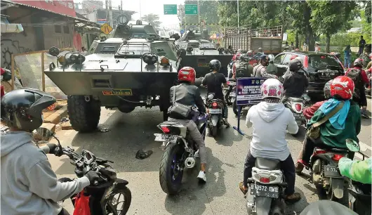  ?? SALMAN TOYIBI/JAWA POS ?? DIHADANG PANSER: Panser dari Kodam Jaya dan Barracuda dari Brimob bersiaga di pos penyekatan pembatasan mobilitas saat PPKM darurat di Jalan Raya Lenteng Agung, Jakarta Selatan, kemarin.
