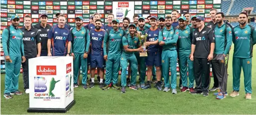  ??  ?? Pakistan and New Zealand players pose with the trophy after the ODI series ended 1-1 with the third match abandoned due to rain. —
