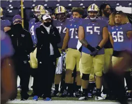  ?? TED S. WARREN — THE ASSOCIATED PRESS ?? Washington coach Jimmy Lake, center left, pulled out of the Pac-12 title game with USC on Friday due to COVID-19 issues.