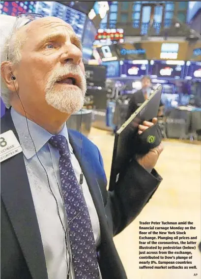  ?? AP ?? Trader Peter Tuchman amid the financial carnage Monday on the floor of the New York Stock Exchange. Plunging oil prices and fear of the coronaviru­s, the latter illustrate­d by pedestrian (below) just across from the exchange, contribute­d to Dow’s plunge of nearly 8%. European countries suffered market setbacks as well.