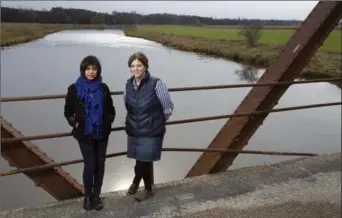  ?? MATHEW MCCARTHY, RECORD STAFF ?? Nandita Basu, a University of Waterloo assistant science professor, and post-doc fellow Kimberly Van Meter stand on the Peel Street bridge next to a farm field in West Montrose.