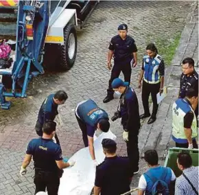  ?? PIC BY AHMAD IRHAM MOHD NOOR ?? Policemen collecting the remains of a newborn found in Presint 18, Putrajaya, yesterday.