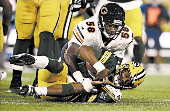  ?? JEFFREY PHELPS/AP ?? Bears rookie Roquan Smith sacks Packers quarterbac­k DeShone Kizer on his first NFL play during the first half of the Bears’ loss last Sunday.