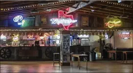  ?? ANGELA PIAZZA / VICTORIA ADVOCATE ?? Neon signs hang over the main bar at Schroeder Hall, near Victoria. The hall is about 14,000 square feet, has a 6,000-square-foot oak dance floor and sits on 5 acres, according to the owner, ATX Brands, based in Austin.