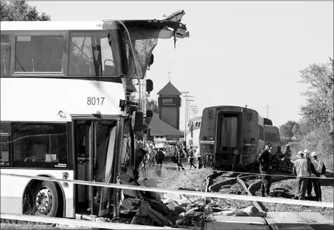 ?? — Photo by The Canadian Press ?? An OC Transpo bus sits where it collided with a Via Rail train during the morning commute Wednesday in Ottawa.