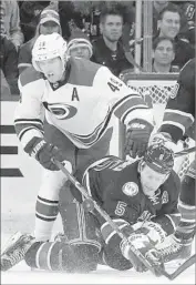  ?? Julie Jacobson Associated Press ?? DAN GIRARDI of the New York Rangers falls as Victor Rask of Carolina applies pressure.