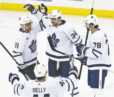  ?? BILL KOSTROUN / THE ASSOCIATED PRESS ?? Maple Leafs centre Auston Matthews celebrates his goal with Max Domi, left, TJ Brodie
and Morgan Rielly on Tuesday against the New Jersey Devils in Newark, N.J.