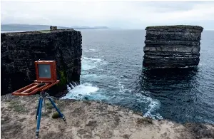  ?? ?? From left: Alex lugging heavy camera gear on one of his early photograph­ic adventures; angling for the perfect shot; Ceapabhal, Isle of Harris.