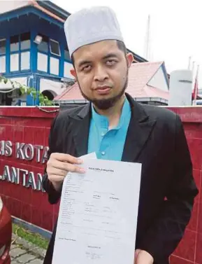  ?? PIC BY ZAMAN HURI ISA ?? Afiq Luqman Mohd Baharudin with a police report he lodged in June.