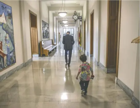  ?? KAYLE NEIS ?? Young Gus Meili follows dad Ryan Meili as the NDP leader walks through the Legislativ­e Building on Thursday.