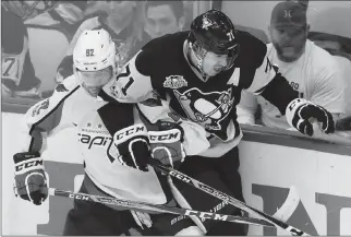  ?? Associated Press photo ?? Pittsburgh Penguins' Evgeni Malkin (71) is pinned along the boards by Washington Capitals' Evgeny Kuznetsov during the third period of Game 6 in an NHL Stanley Cup Eastern Conference semifinal hockey game in Pittsburgh, Monday.