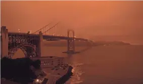  ?? HAROLD POSTIC/AFP VIA GETTY IMAGES ?? Cars drive along the Golden Gate Bridge under an orange, smoke-filled sky in San Francisco on Sept. 9.