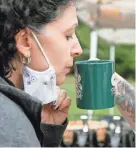  ?? COLUMBUS DISPATCH BARBARA J. PERENIC/ ?? Kim Coolidge, of Grove City, takes a sniff of a flavored coffee at the Silverbrid­ge Coffee Company tent during the Columbus Coffee Festival at the Ohio History Connection’s Ohio Village on Saturday.