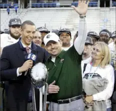  ?? Associated Press ?? UAB coach Bill Clark accepts the Conference USA championsh­ip trophy after the Blazers defeated Middle Tennessee, 27-25, Saturday in Murfreesbo­ro, Tenn.