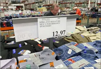  ?? DAVID ZALUBOWSKI — THE ASSOCIATED PRESS ?? A sign displays the price for shirts as a shopper peruses the offerings at a Costco warehouse in this photograph taken Thursday, June 17, in Lone Tree, Colo. Growth in U.S. consumer spending slowed in July to a modest increase of 0.3% while inflation over the past 12 months rose to the fastest pace in three decades.