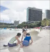  ?? Tassanee Vejpongsa Associated Press ?? A FAMILY plays in the sand this week in Tamuning, Guam. The island is home to 160,000 people.