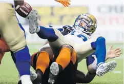  ??  ?? Winnipeg QB Alex Ross, top, fumbles the ball while being tackled by B.C. Lions’ Davon Coleman, bottom, in Vancouver on June 8.
