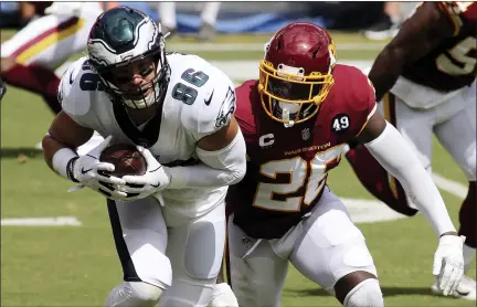  ?? DANIEL KUCIN JR. — THE ASSOCIATED PRESS ?? Philadelph­ia Eagles tight end Zach Ertz (86) slips past Washington Football Team safety Landon Collins (20) during a match the against the Washington Football Team in an NFL game, Sunday, September 13, 2020 in Landover, Md.