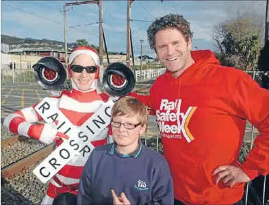  ??  ?? Careful crossing: Chris Cairns and one of two actors in crossing costumes handed out ‘Use Your Brain, Tracks Are For Trains’ leaflets last week. Flynn Cubitt from Tawa Intermedia­te got the message.