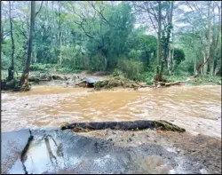  ?? ASSOCIATED PRESS ?? A bridge off Peahi Road is overcome by floodwater­s above the Kaupakalua Reservoir and Dam after heavy rainfall on Monday in Haiku, Maui on Monday.