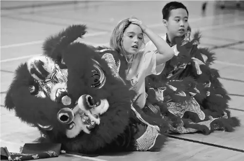  ?? LARRY WONG/ EDMONTON JOURNAL ?? Lion dancers take a break during a Chinese New Year celebratio­n at Dovercourt Elementary School in January. Dovercourt is one of 12 Edmonton public schools offering Mandarin, but demand for the program far outstrips school space.