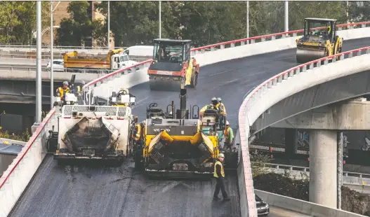  ?? DAVE SIDAWAY ?? Workers pave the ramp from eastbound Highway 20 toward the Décarie Expressway, which is expected to be reopened on Monday.