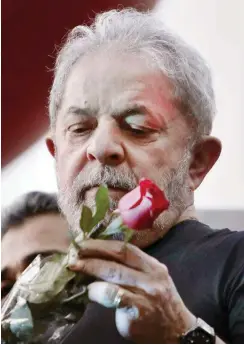  ?? Foto: AFP/Miguel Schincario­l ?? Rose zur Unterstütz­ung: Lula in schweren Zeiten