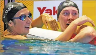  ?? The Canadian Press ?? Kelowna’s Taylor Ruck, right, checks her time after winning the women’s 200-metre freestyle final at the Pan Pacific swimming championsh­ips in Tokyo on Thursday. At left is second-place Rikako Ikee.