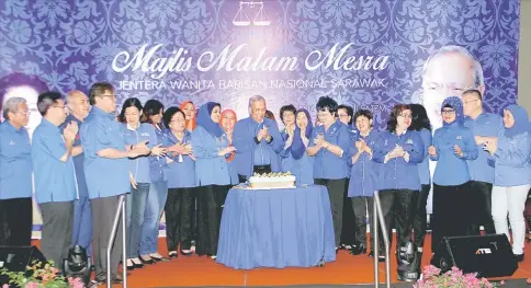  ??  ?? Adenan (centre), Shahrizat (on Adenan’s right), state dignitarie­s and women chiefs from other BN component parties celebrate after the cake cutting ceremony to mark Adenan’s second anniversar­y as chief minister. — Photo by Chimon Upon