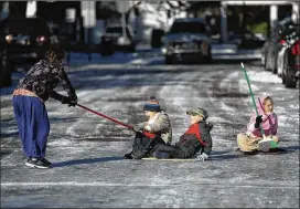  ?? JOE RAEDLE PHOTOS / GETTY IMAGES ?? (From left) Telem Fenster, Jediah Pendergras­s, Shebuel Fenster and Keren Fenster play on an icy street Thursday in Savannah. From Maine to Florida, every state on the East Coast is expected to have to deal with winter weather.