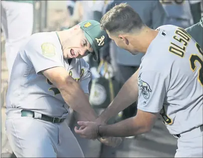  ?? JOHN FROSCHAUER — THE ASSOCIATED PRESS ?? Josh Phegley, left, and Matt Olson joke in the playoff-bound A’s dugout before Monday night’s game against the Mariners in Seattle.