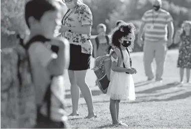  ?? [BRYAN TERRY/ THE OKLAHOMAN] ?? Kindergart­ner Aubree Freeman, 6, waits in line after she was dropped off for her first day of school at Charles Haskell Elementary in Edmond on Aug. 20. Edmond Public Schools opted for a blended learning model which has students alternate between at-home learning and attending class in person.