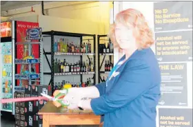  ??  ?? Mayor Tracey Collis cuts the ribbon to open the new Black Bull bottle store in Woodville.
