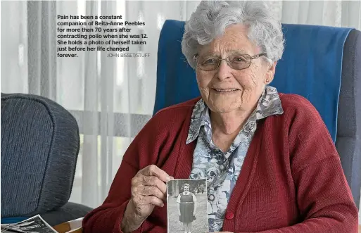  ?? JOHN BISSET/STUFF ?? Pain has been a constant companion of Reita-Anne Peebles for more than 70 years after contractin­g polio when she was 12. She holds a photo of herself taken just before her life changed forever.
